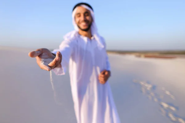 Close-up shot of portrait and hands of young Arab guy in sandy d — Stock Photo, Image