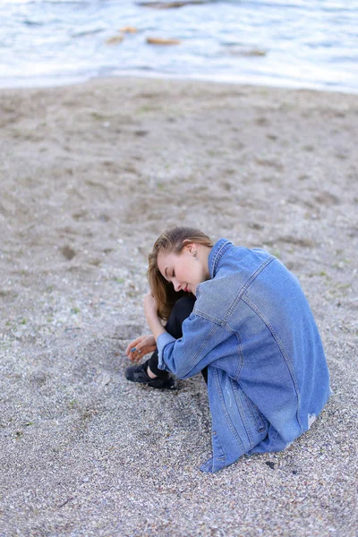 Dinlenme, deniz kenarında oturan ve b kameraya poz güzel kız