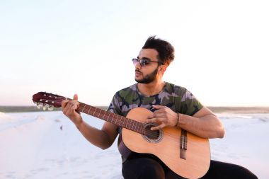 Arap yakışıklı genç gitar mi Hill'de oturan, ayarlar