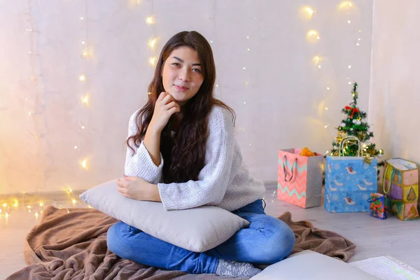 Charmig kvinna poserar på kamera på julafton och sitter på — Stockfoto
