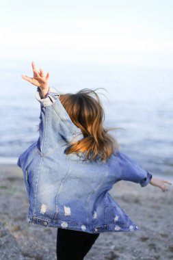 Çekici kız sahil boyunca yürür ve neşeyle kum üzerinde aptallar