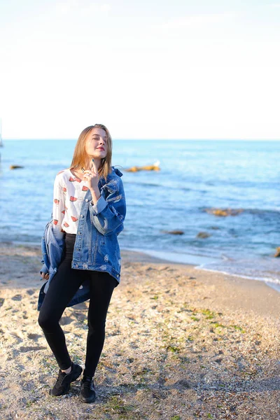 Çekici kız sahil boyunca yürür ve neşeyle kum üzerinde aptallar — Stok fotoğraf