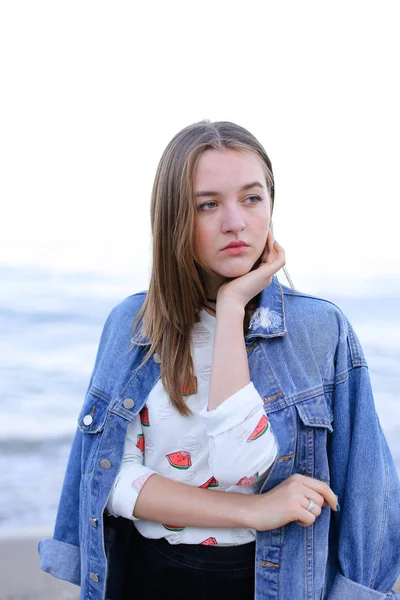 Sevimli kadın kamera, sahil sakin su üzerinde ayakta poz