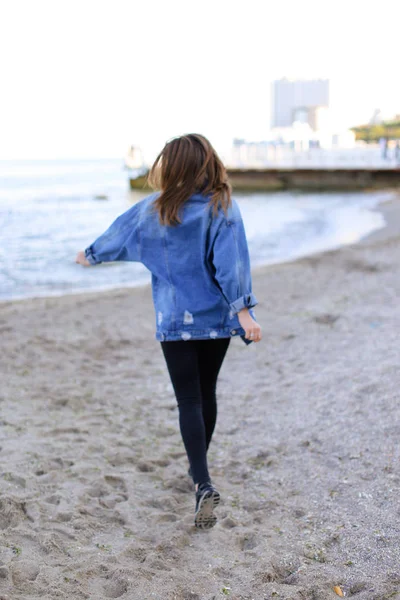 Sevimli kadın gülümseme ile teşkil etmektedir ve deniz kıyı savaş yürür