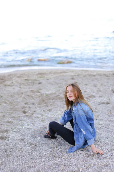 Piękna dziewczyna, odpoczynek, siedzi nad morzem i pozowanie na kamery na b — Zdjęcie stockowe