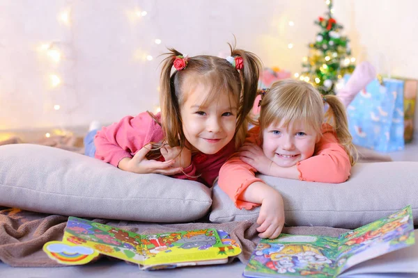 Sevimli küçük kızlar birlikte oynamak ve sohbet, yerde yatıyor ve