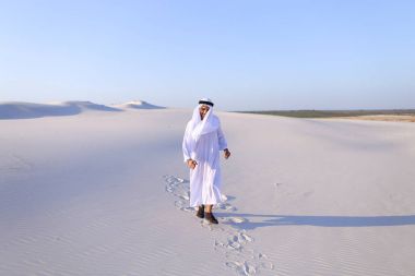Mutlu Arap babası beyaz çöl ortasında yürüyor ve yaşam o sever