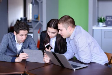 Üç meslektaşları, kadın ve iki genç adamın sosyal ağ içinde oturmak