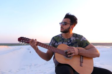 Arap yakışıklı genç gitar mi Hill'de oturan, ayarlar