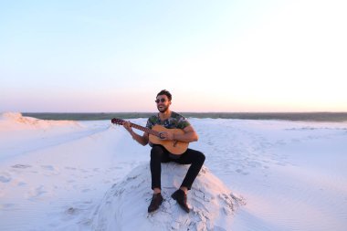 Sevimli genç erkek Arap ses gitar, Hill'de oturan sahiptir