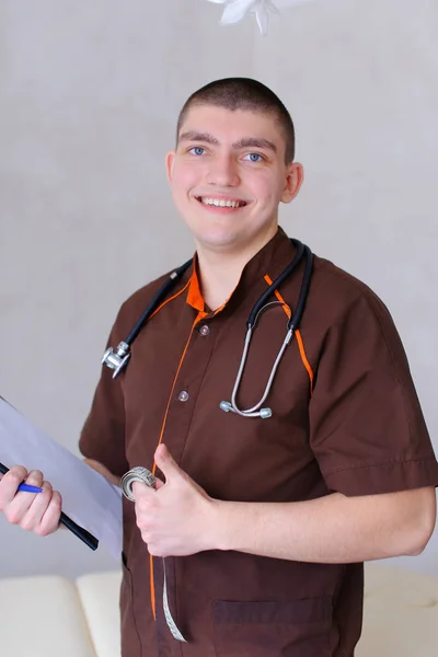 Professional male therapist looks at camera with smile and stand