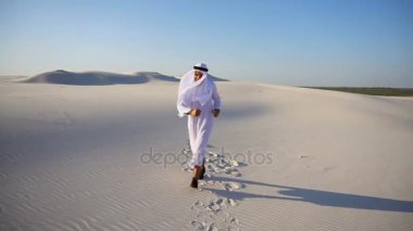 Neşeli genç erkek Arap BAE Şeyh Emirliği hayatta sevinir ve açık akşamı çölün expanses yürüyor.