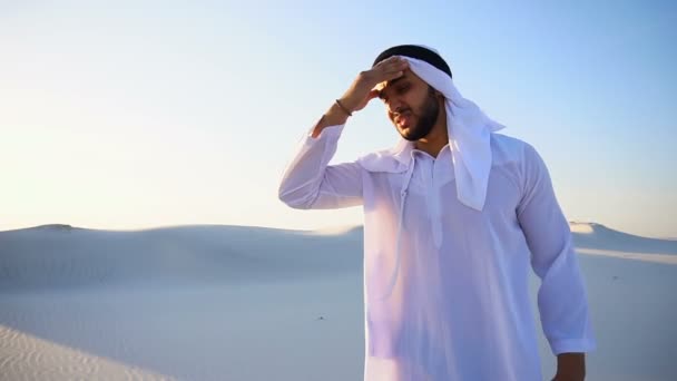 Muslim man feels headache and general malaise, suffers from standing in middle of sandy desert on warm summer day. — Stock Video