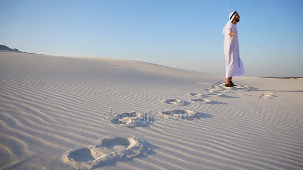 Emiraten Arabische sjeik in goede geesten loopt rond natuur in zandwoestijn en geniet van de heldere dag in open lucht. — Stockvideo
