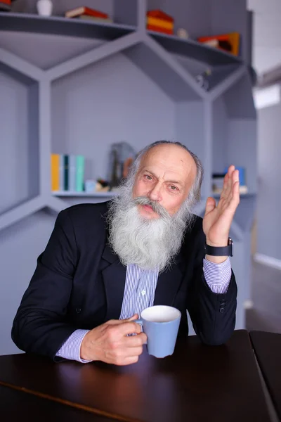 Retrato de un anciano inteligente que reflexiona sobre la vida y posando con —  Fotos de Stock