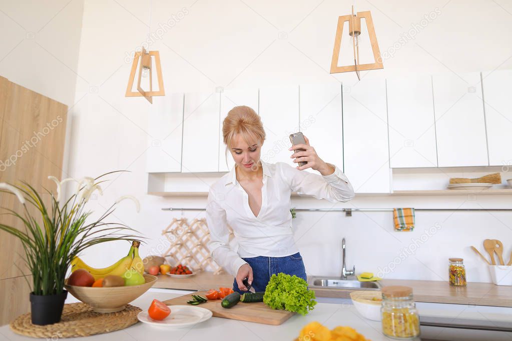 Alluring woman holds mobile phone and calls video call, standing