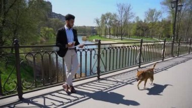 Gönüllülük iş kağıtları ve köpek adam ağır çekimde köprüsü üzerinde çalışır..