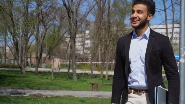 Échange étudiant marchant dans le parc, au ralenti et montrant la main de signe de paix . — Video