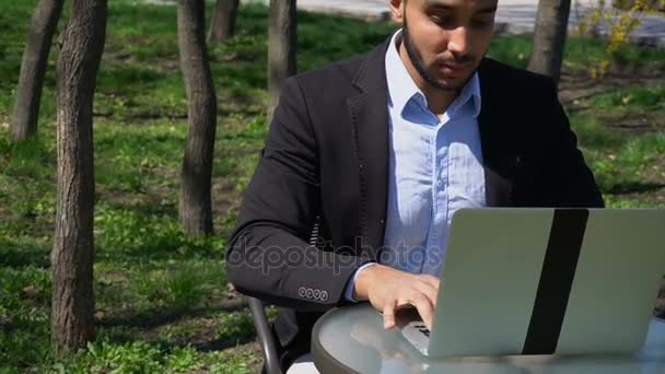 Arquiteto muçulmano clicando laptop e pensando em novo projeto, câmera lenta . — Vídeo de Stock