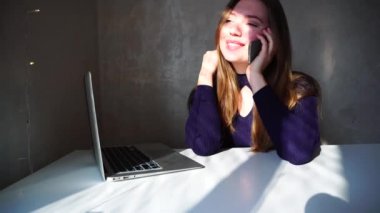 Telefon kullanarak ve toplantı hakkında soran onun erkek arkadaşı ile konuşurken gülümseyen kız.