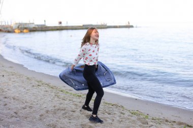 Çekici kız sahil boyunca yürür ve neşeyle kum üzerinde aptallar