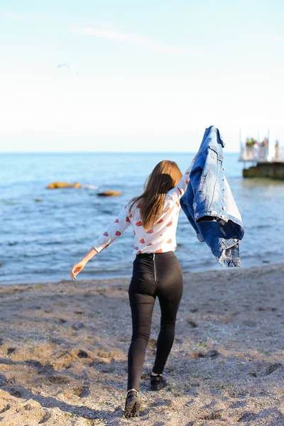 Glückliche junge Frau genießt sonniges Wetter und posiert am Ufer des Sees — Stockfoto