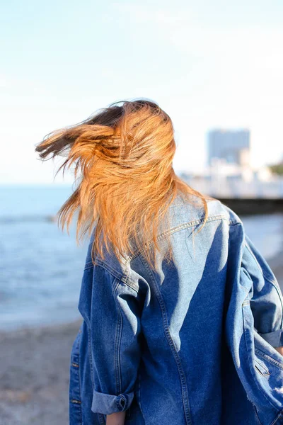 Счастливая молодая женщина отращивает волосы и позирует на камеру стоя — стоковое фото
