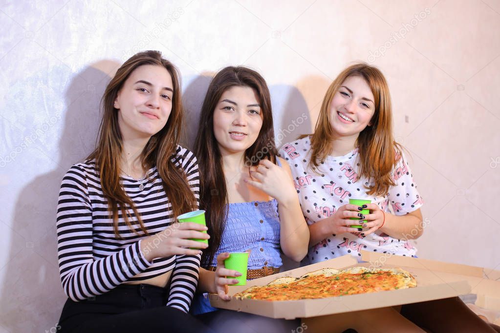 Cute girls cool spend time and enjoy pizza, sit on floor in brig