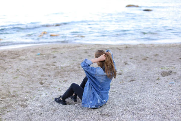 Menina bonita descansando, sentado no mar e posando na câmera em b — Fotografia de Stock