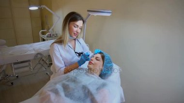 Doktor istemci oturur, ağır çekimde el tıbbi malzeme tutar.