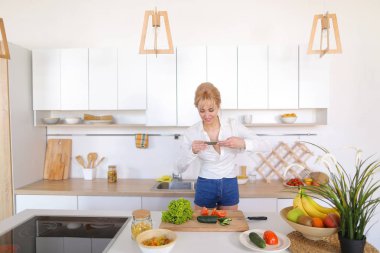 Mutfak kız smartphone elinde tutan ve sebze fotoğrafı çeker