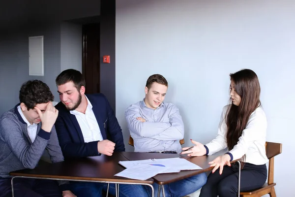 Hombres inteligentes y mujeres jóvenes pelean y hacen las tareas para desarrollar — Foto de Stock