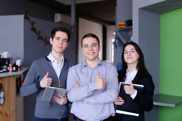 Üç kendine güvenen erkek ve kız öğrenci veya w ayağa çalışanlar