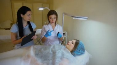 İstemci ile kozmetik prosedürler hakkında doktorlar konuşuyor.