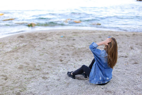 Menina bonita descansando, sentado no mar e posando na câmera em b — Fotografia de Stock