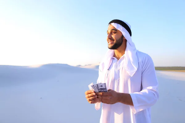 Successful Arab sheikh considers banknotes and happy, standing i — Stock Photo, Image