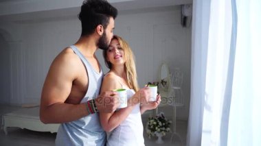 Günaydın insanlar birbirlerini yatak arka plandaki tabloda ve kozmetik renkler yanında hafif yatak odasında sevgi dolu.