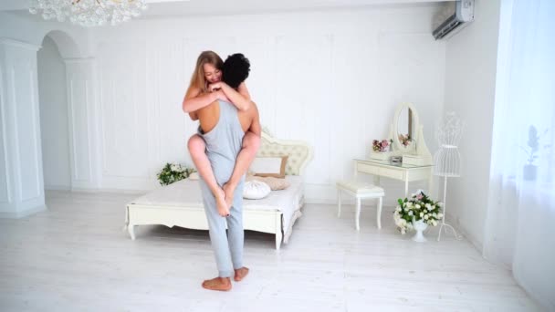 Amar uns aos outros par estão em cada outros braços e felizes juntos no quarto no fundo da cama e decoração . — Vídeo de Stock