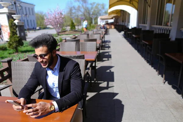 Arabian guy talking with friendby phone — Stock Photo, Image