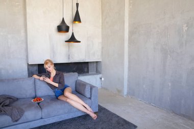 Sarışın göz kamaştırıcı smartphone kullanır ve olgun çilek, sitti çalışır