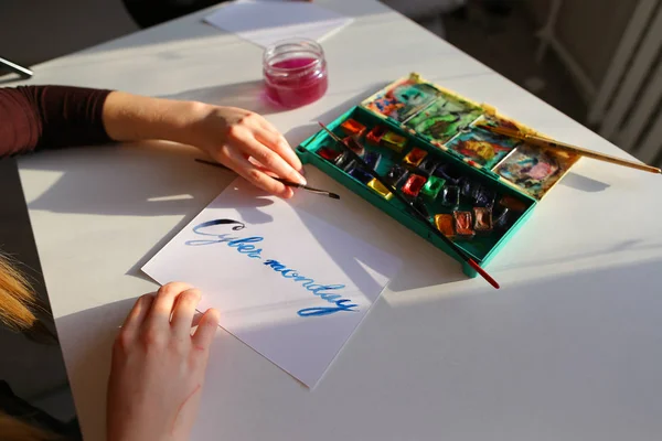 Θηλυκό καλλιγράφος δημιουργεί επιγραφή προς πώληση, χρησιμοποιώντας βούρτσες — Φωτογραφία Αρχείου