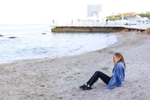 Güzel ve genç birbayan sahilde oturan rahatlatır ve görünümü o sahiptir