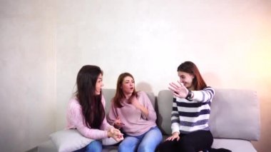 Şirin kızlar bakarak ve parlak yatak odasında kanepede oturan şık akıllı saat eğitim.