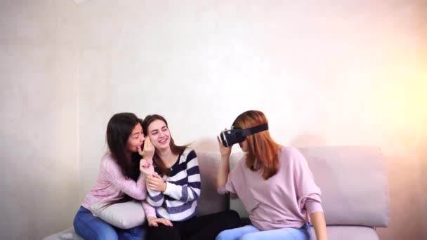 Moderna kvinnor studera och Visa nya glasögon av parallell verklighet sittande på soffan i ljusa sovrum. — Stockvideo