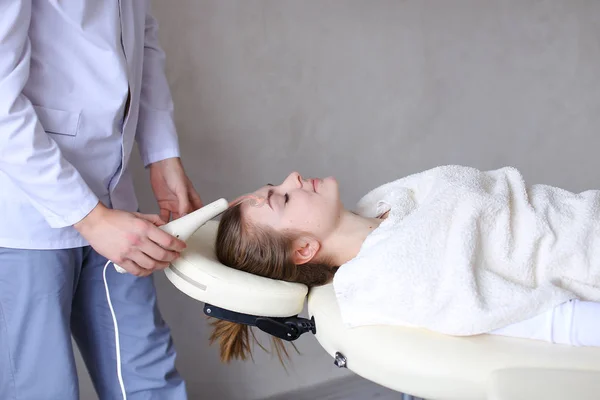 Cosmetologist guy makes special face massage to girl with cosmet — Stock Photo, Image