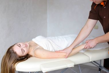 Deneyimli adam hekim el ile manuel masaj yöntemi uygular