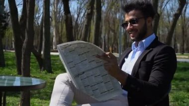 Öğle yemeğinde gazete okuyan başarılı iş adamı.