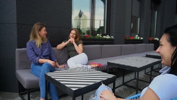 Drei Mädchen diskutieren Jungs in neuem Café und lachen. — Stockvideo