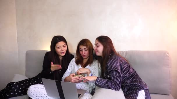 Amigável feminino assistindo filmes no laptop e sentado no sofá macio no quarto brilhante à noite — Vídeo de Stock