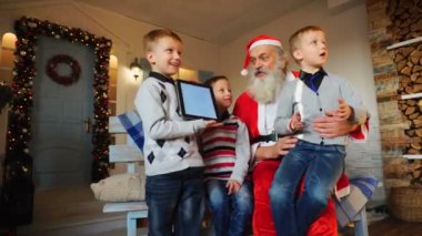 Küçük çocuklar Noel Baba tablet gösterilen.